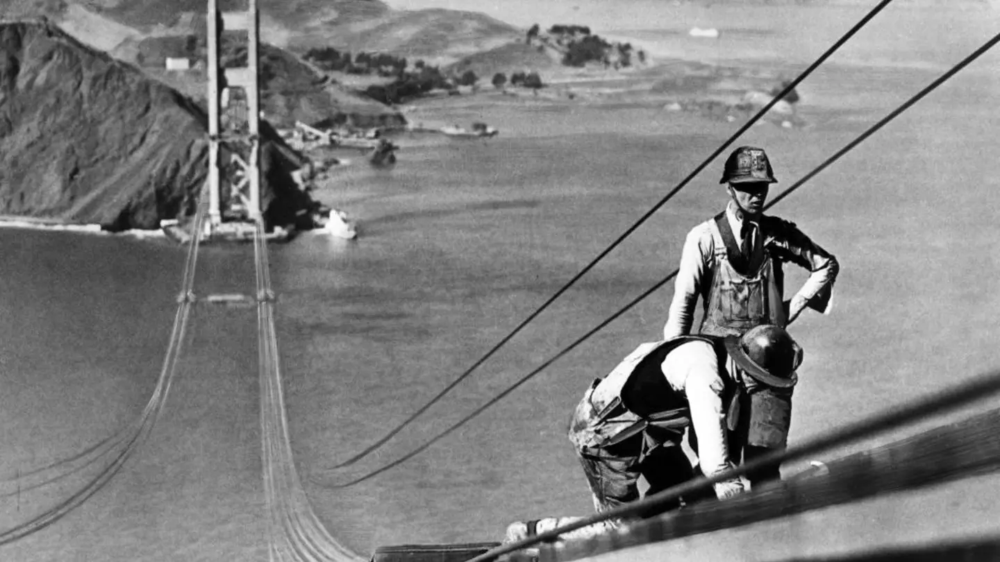 Bridge workers installing suspension cables